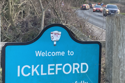 Ickleford village sign with queued traffic